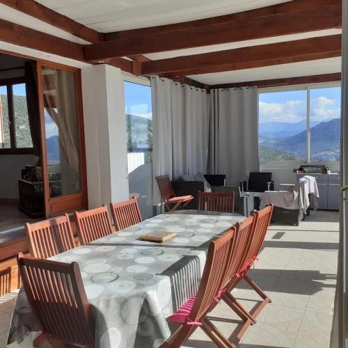 a dining room with a table and chairs on a patio at Villa conviviale à Olmeto avec piscine privée in Olmeto