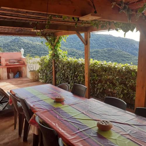 a table and chairs in a room with a view at Villa conviviale à Olmeto avec piscine privée in Olmeto