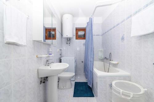 a white bathroom with a toilet and a sink at Villa NV View 22 by aneo travel in Novi Vinodolski