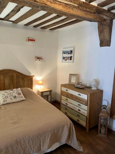 een slaapkamer met een bed en een houten dressoir bij Une Pause Chez Julien, appartement lumineux et idéalement situé! in Honfleur