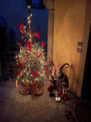 a christmas tree in a room with a dinosaur next to it at Acacia Tree Lodge il tuo rifugio sul Lago Maggiore in Lesa