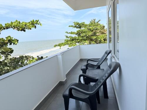 two chairs on a balcony looking out at the ocean at Golden Sands Cherai in Cherai Beach