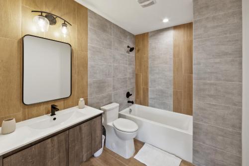 a bathroom with a tub and a toilet and a mirror at Market View Residence 504 I 2 Bedroom 2 Bathroom in Wilmington
