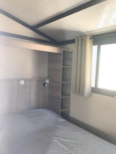 une chambre avec un lit et une fenêtre dans l'établissement Chalet cosy à Corbara, vue mer, à Corbara