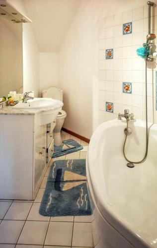 une salle de bain avec une baignoire, un lavabo et des toilettes dans l'établissement Maison charmante au Vaudreuil avec magnifique jardin clos, à Le Vaudreuil