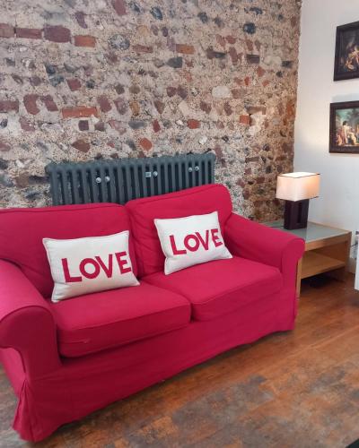 a red couch with love pillows on it in a living room at Number Three in Brighton & Hove