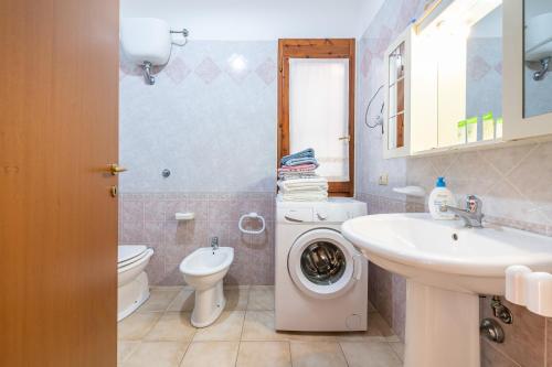 a bathroom with a washing machine and a sink at Casa Vacanze delle More in Costa Rei