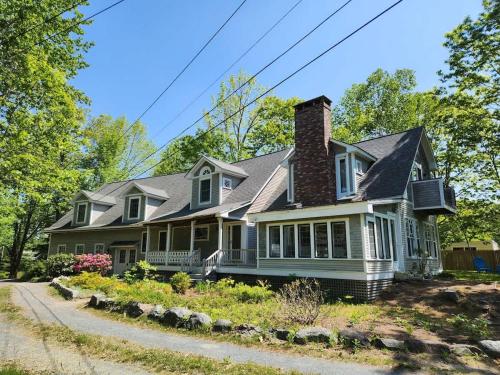 une maison verte avec une cheminée dans une rue dans l'établissement Acadia Lobsterman's Farmhouse & Cottage, à Lamoine Beach