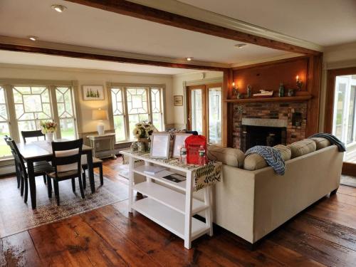 un salon avec un canapé et une salle à manger dans l'établissement Acadia Lobsterman's Farmhouse & Cottage, à Lamoine Beach