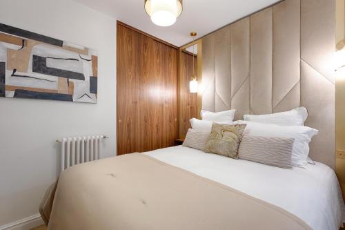 une chambre avec un grand lit avec des oreillers blancs dans l'établissement Serviced Apartment - 6 Guests - Champs-Élysées, à Paris