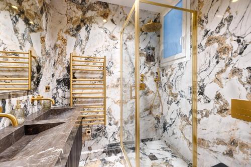 La salle de bains est pourvue d'un mur en marbre. dans l'établissement Serviced Apartment - 6 Guests - Champs-Élysées, à Paris