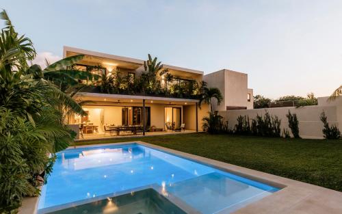 a swimming pool in front of a house at Luxury Modern Villa Puerto Aventuras - Rivera Maya in Puerto Aventuras