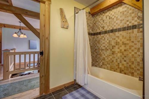 ein Badezimmer mit ebenerdiger Dusche neben einer Badewanne in der Unterkunft Acadia Lobsterman's Secret Cottage in Lamoine Beach