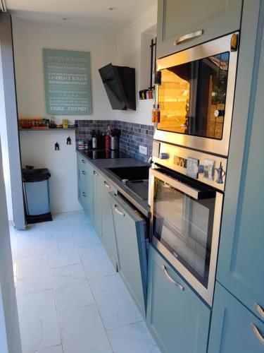 La cuisine est équipée de placards bleus et d'un four avec plaques de cuisson. dans l'établissement coin de paradis, à La Londe-les-Maures