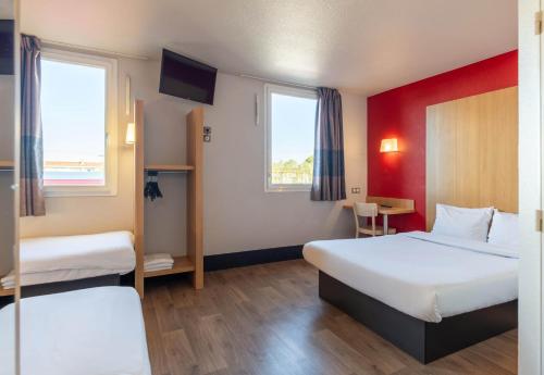 a hotel room with two beds and two windows at B&B HOTEL Lyon Vénissieux in Vénissieux