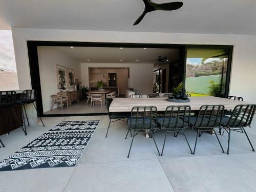 a dining room with a white table and chairs at Luxury Modern Villa Puerto Aventuras - Rivera Maya in Puerto Aventuras