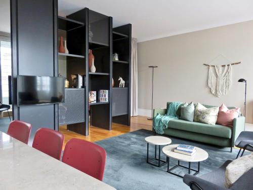 a living room with a green couch and a table at Oporto Serviced Apartments - Miragaia II in Porto