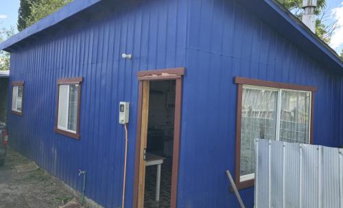 a blue building with a door and windows at departamento el coiron in Cochrane