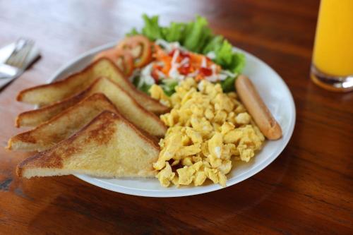 a plate of breakfast food with eggs toast and a salad at Kelingking Tatakan Bungalow in Nusa Penida