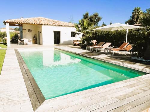 - une piscine avec des chaises et un parasol à côté d'une maison dans l'établissement Villa, à Roquebrune-sur Argens