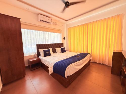 a bedroom with a bed and a large window at Golden Sands Cherai in Cherai Beach