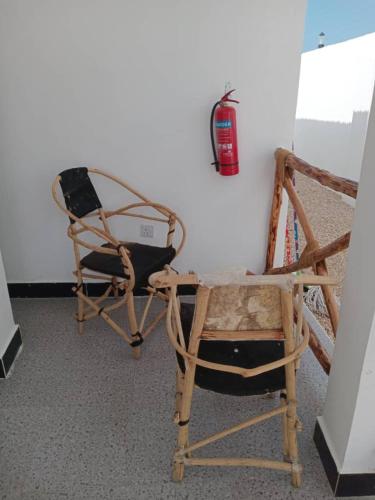 two chairs and a fire extinguisher on a wall at KATALE Villa in Jambiani