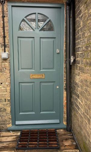a green door with a window and a brick wall at 1 bed flat in central Cambridge in Cambridge
