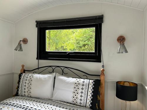 a bedroom with a bed with a window above it at Flying Scotsman Unique Carriage Pet Friendly! Lazy Spa can be available upon request with additional cost of 40 in Bridgend