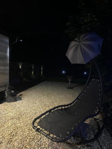 a black slide with an umbrella in the dark at Flying Scotsman Unique Carriage Pet Friendly! Lazy Spa can be available upon request with additional cost of 40 in Bridgend