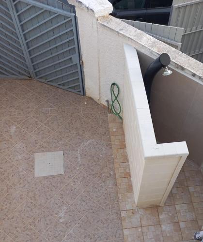 a white bench next to a wall with a pair of scissors at Meerblick-Ferienhaus Casa Gino Apulien in San Pietro in Bevagna