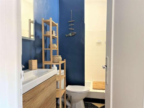 une salle de bain avec toilettes et un mur bleu dans l'établissement Appartement 2 pièces vue mer Port La Nouvelle PN400-034, à Port-la-Nouvelle