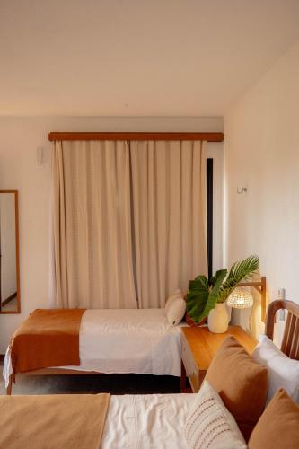 a hotel room with two beds and a window at Teça Suites in Guriú