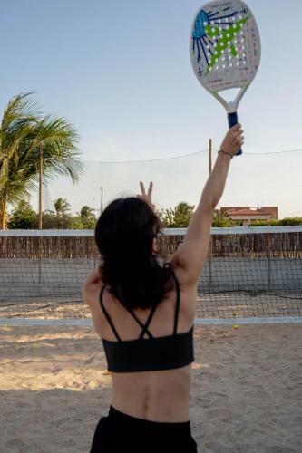 a woman in a bikini holding a tennis racket at Teça Suites in Guriú