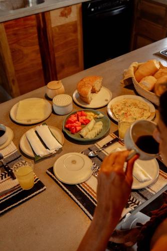 a table with food and plates of food on it at Teça Suites in Guriú