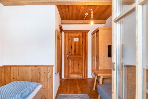 a room with a bed and a table and a door at Schwüwong - Apartment 22 in Kelchsau