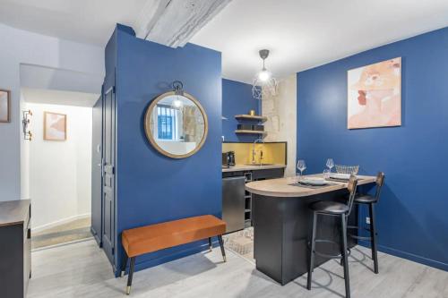 une salle à manger avec des murs bleus et une table avec un miroir dans l'établissement Le spa du Donjon- Rouen Gare, à Rouen
