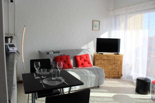 - un salon avec un canapé et une table avec des verres à vin dans l'établissement Appartement studio PORT LA NOUVELLE PN590-014, à Port-la-Nouvelle