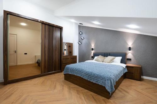 una camera da letto con un letto e un grande specchio di Chic and Modern 4 Bedroom Home in Central Tbilisi a Tbilisi City
