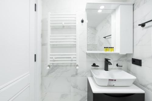 un bagno bianco con lavandino e specchio di Chic and Modern 4 Bedroom Home in Central Tbilisi a Tbilisi City