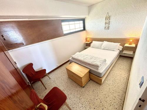 une petite pièce avec un lit et une chaise dans l'établissement Appartement 2 pièces - Port La Nouvelle PN590-025, à Port-la-Nouvelle