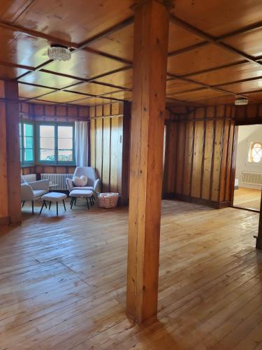 a large room with wooden floors and wooden beams at Refugio Heiligkreuz in Hasle