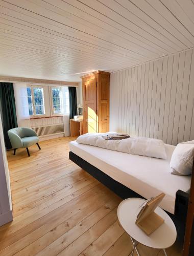 a bedroom with a large bed and a chair at Refugio Heiligkreuz in Hasle