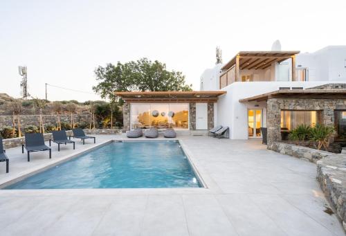 a pool in a backyard with chairs and a house at Ambiente Villas 3Βd-Agios Ioannis in Agios Ioannis Mykonos