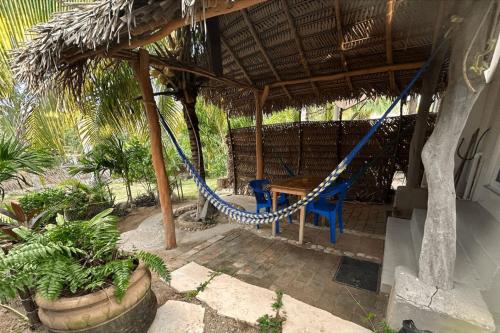 a porch with a hammock and a table and chairs at Shaka Studio - steps to beach in Punta Mita