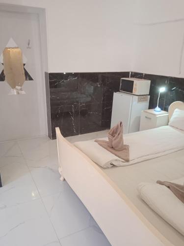 a white room with two beds and a refrigerator at R4 Rolléder Apartman-ház in Siklós