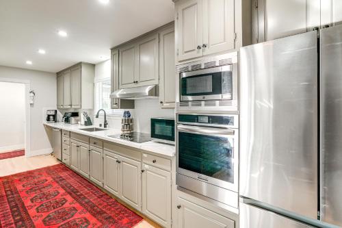 a kitchen with white cabinets and stainless steel appliances at 2 Mi to Beach Home with Patio in Del Rey Oaks! in Del Rey Oaks