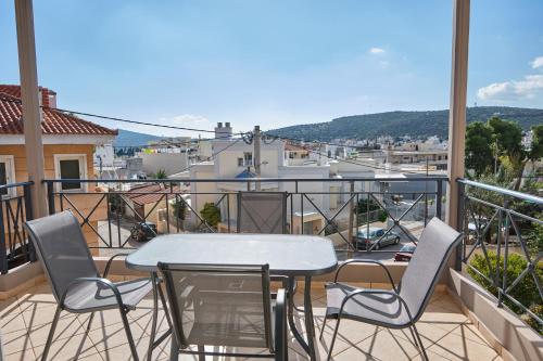 a patio with a table and chairs on a balcony at ATHENS VILLA KROPIA #AthensAirport #AirView #Sunrise in Koropíon