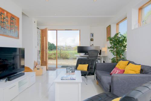 a living room with a couch and a tv at 3 Bedroom Eco house in Chichester near Goodwood in Chichester