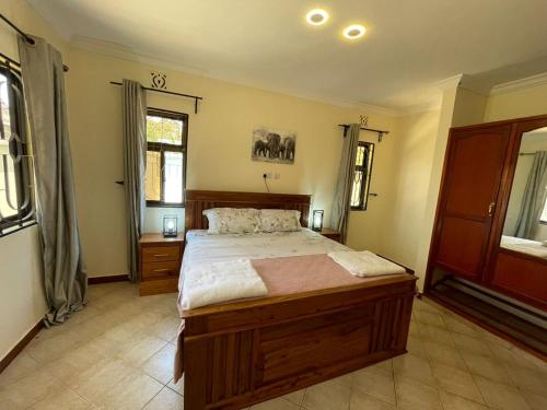 Un dormitorio con una cama grande en una habitación. en Emmalanta Safaris House, en Arusha