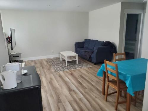 a living room with a blue table and a couch at Brand new entire basement suit in Moncton